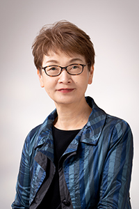 理事長の梶原絹代の画像。ショートカットでメガネをかけている。